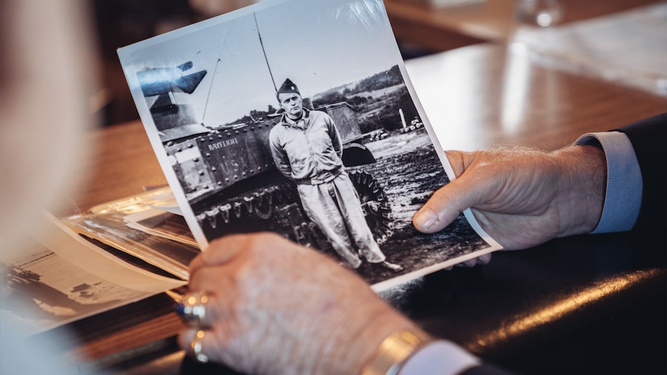 George Patton Waters' hands holding an old picture of Reuben Schaetzel as a young soldier.