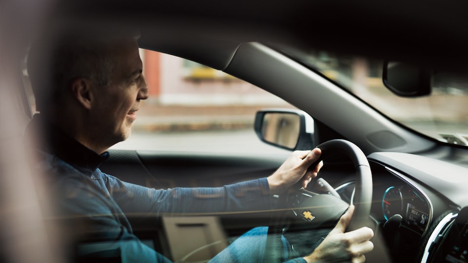 Mike Lucey sitting behind the wheel of his Chevrolet Malibu.