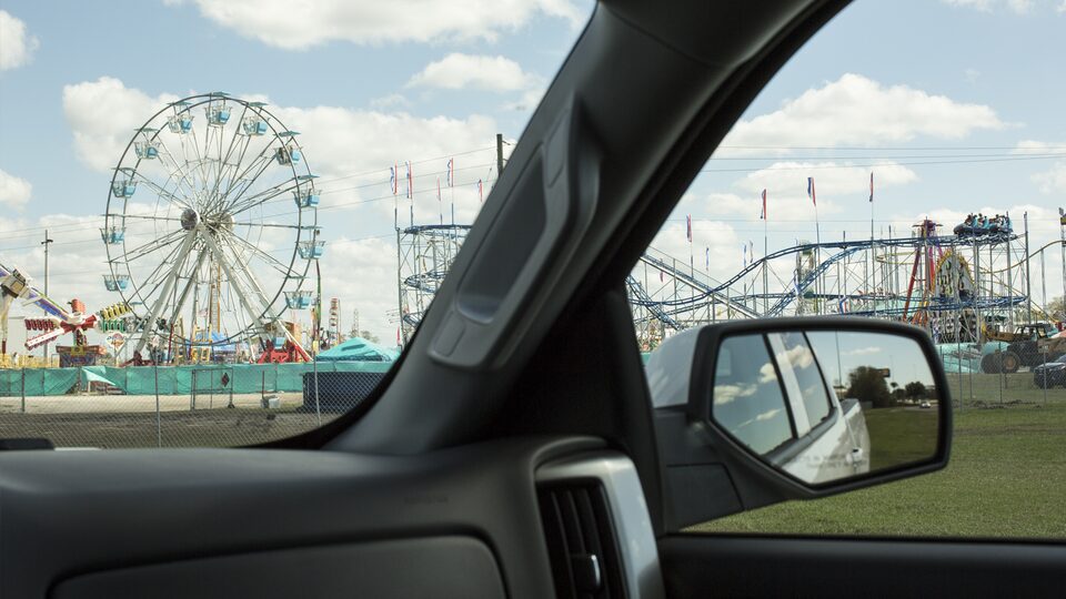 Atracciones de la feria estatal vistas a través del parabrisas de una Chevy Silverado.