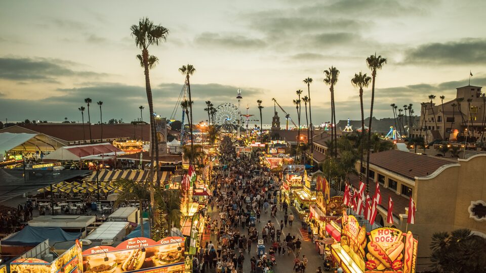 Una feria estatal a mitad de camino iluminada en la oscuridad.