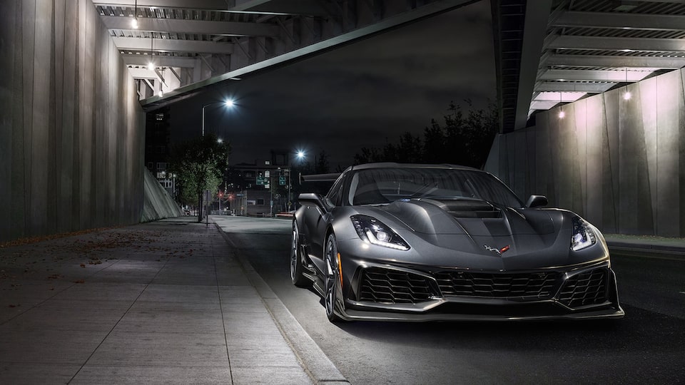 A black 2019 Corvette ZR1 seen from the front under a highway overpass with an empty street behind it.