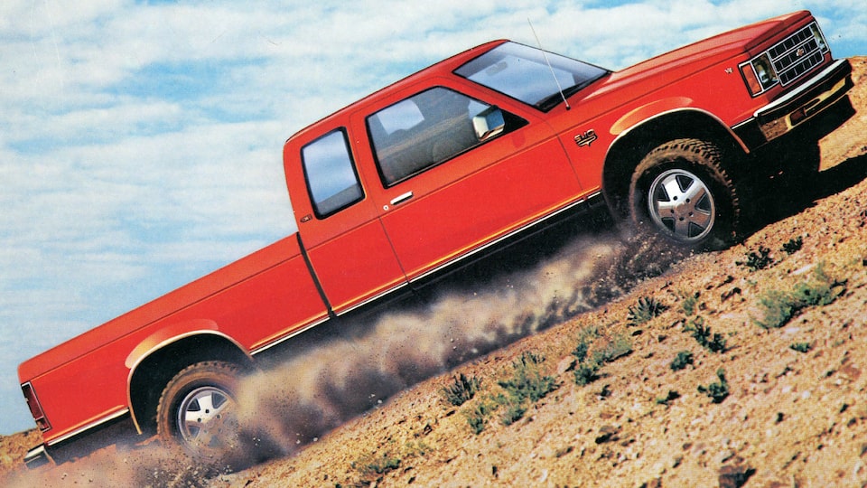 A picture of a red and black twotone Chevy S-10 pickup in the desert from the original 1983 brochure.