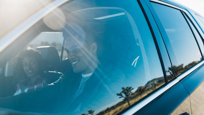Una pareja en los asientos delanteros de la Chevrolet Traverse.