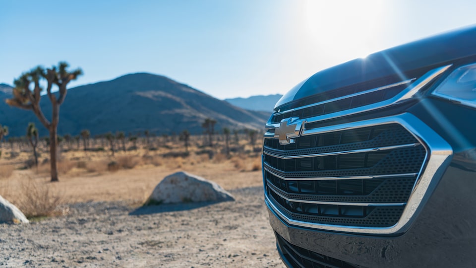 The grille of the Chevrolet Traverse with Joshua trees in the background.