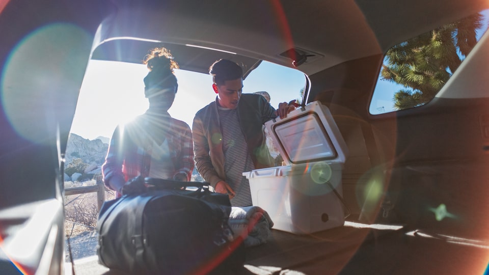 A couple going through gear in the spacious cargo area of the Chevrolet Traverse.