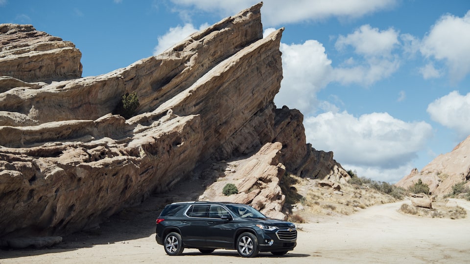Chevrolet Traverse seen in a remote area in front of a rock formation.