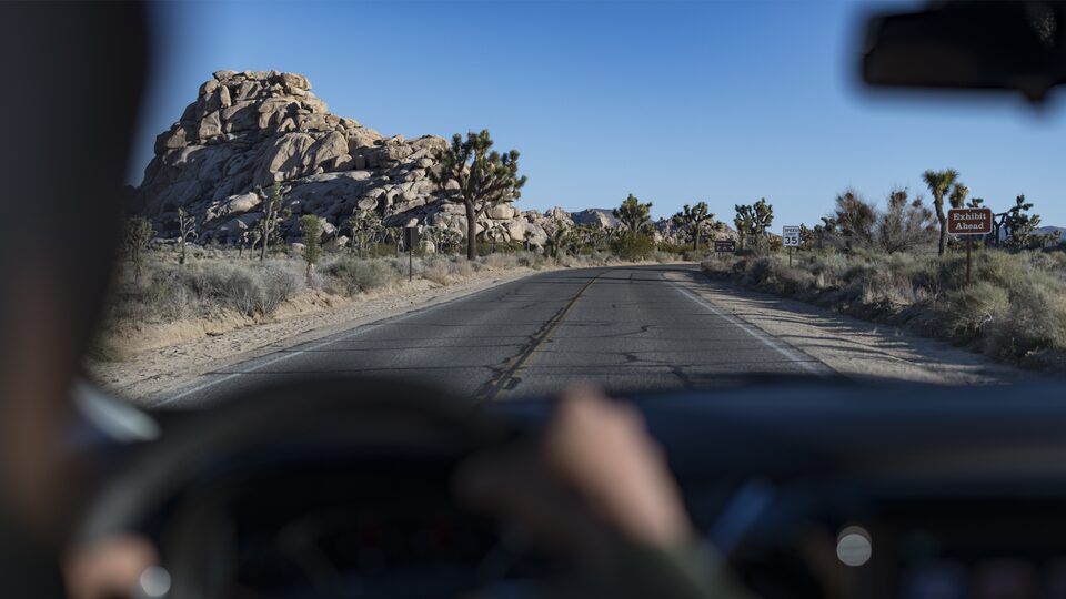 The open desert road as seen through the windshield of a Chevrolet Traverse.