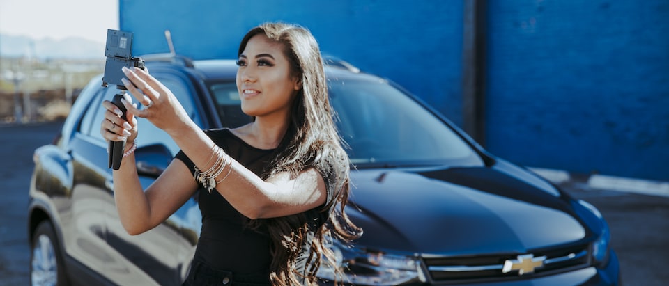 Vlogger Mo Calderon takes a self portrait in front of a Chevrolet Trax.