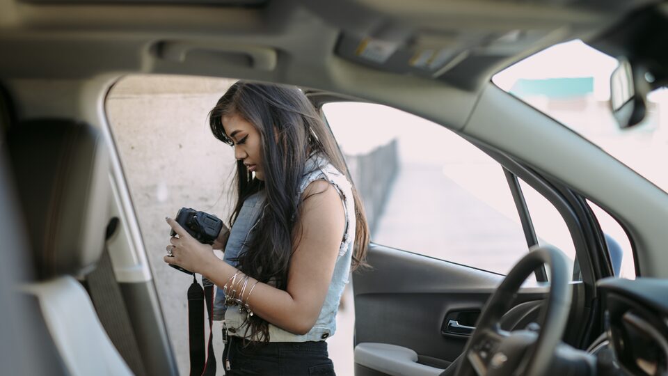 Vlogger Mo Calderon stands outside of the Trax, adjusting her camera.