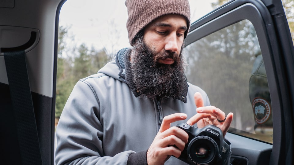 Chris Arace at the open back door of a 2018 Chevy Colorado getting his camera gear out of the truck.