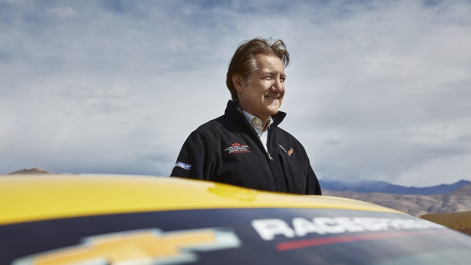 Ron Fellows detrás de un Corvette amarillo.