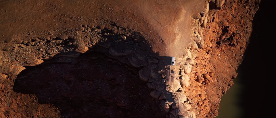 An aerial shot of a Chevrolet SUV at the end of a desert road.