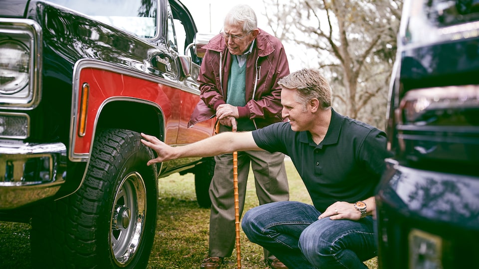 Eric Stanczak y Paul Hitch observan de cerca a una clásica camioneta Chevy que Hitch ayudó a diseñar.