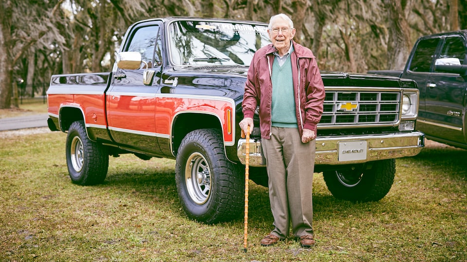 Paul Hitch está parado frente a una camioneta pickup Chevy de la era 70 que él y su equipo ayudaron a diseñar.