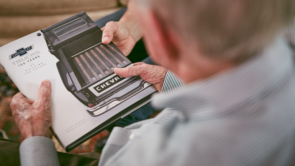 Paul Hitch examina un libro de publicidades históricas de camionetas Chevy.