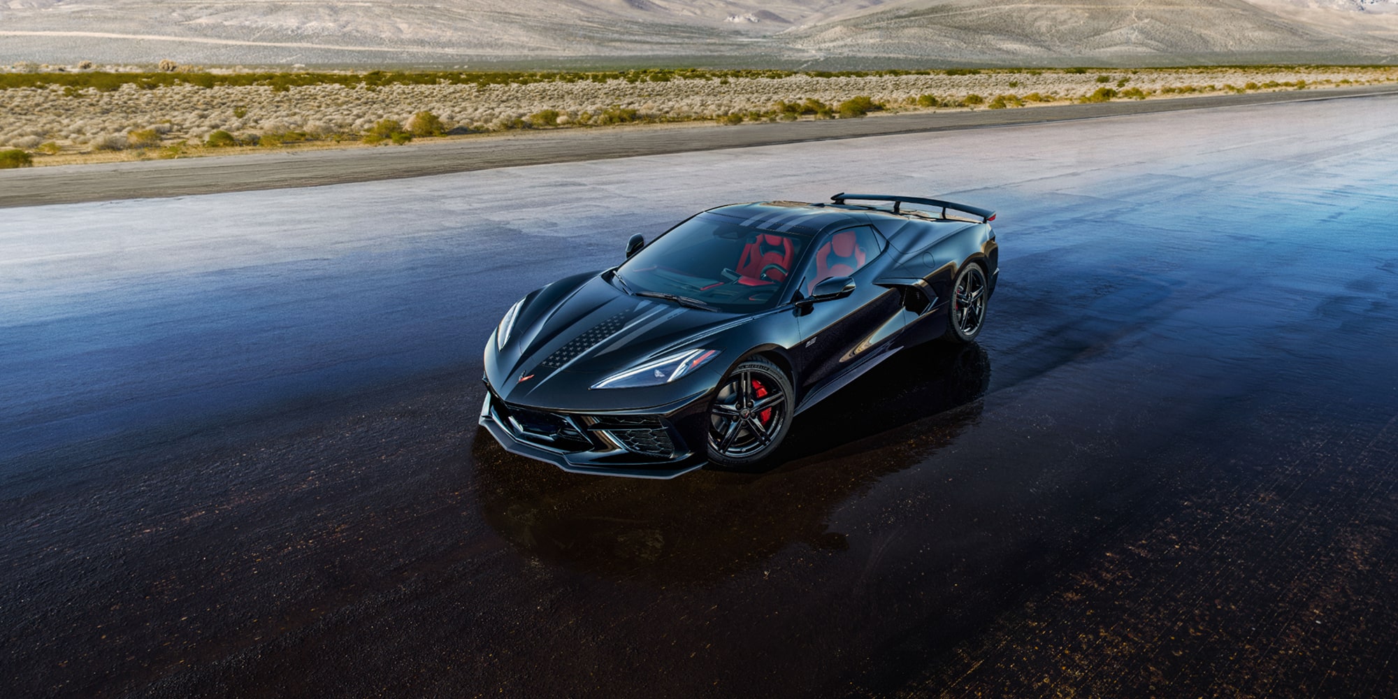 A Dark Blue Chevrolet Corvette Stingray from the Stars and Steel Collection on a Wet Runway.
