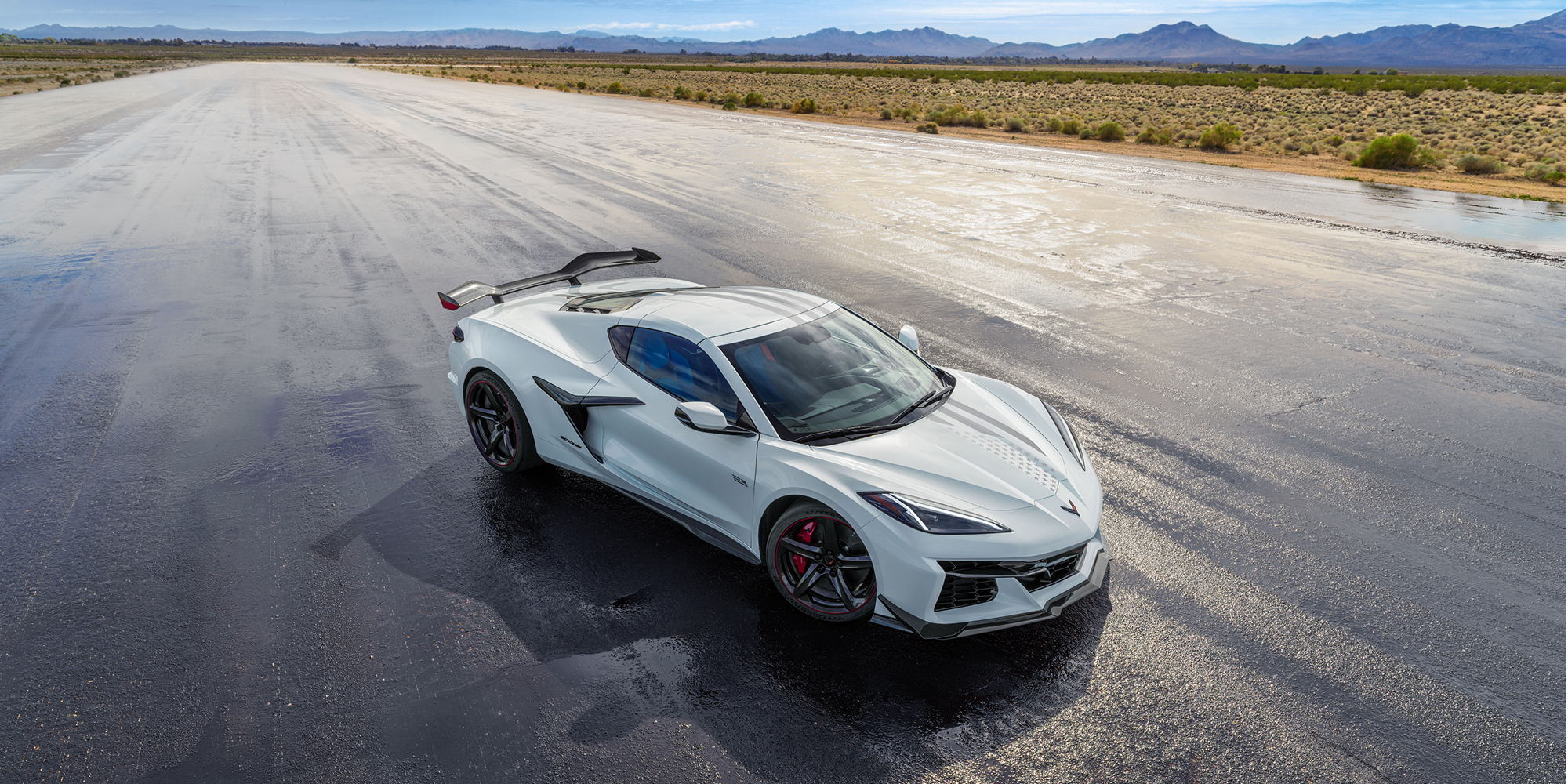 A White Chevrolet Corvette Z06 from the Stars and Steel Collection on a Wet Runway.