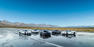 A Collection of Chevrolet Stars and Steel Edition Corvettes on a Wet Surface in a Desert.