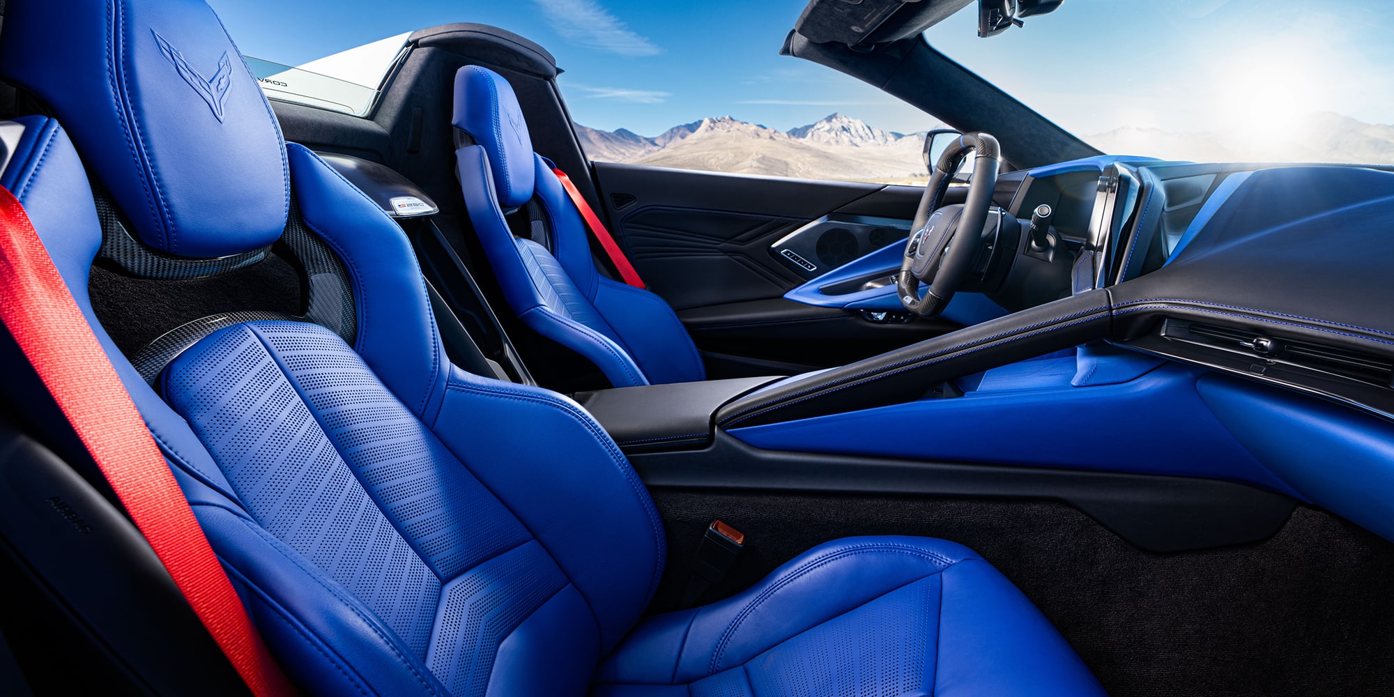 A Wide Interior Shot Of A Chevrolet Cabin Featuring Blue And Red Two-Tone Leather Sport Seats Against A Mountain Backdrop.