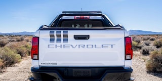 The Rear View of a White Chevrolet Colorado Stars and Steel Truck, Featuring Stripes on the Tailgate.
