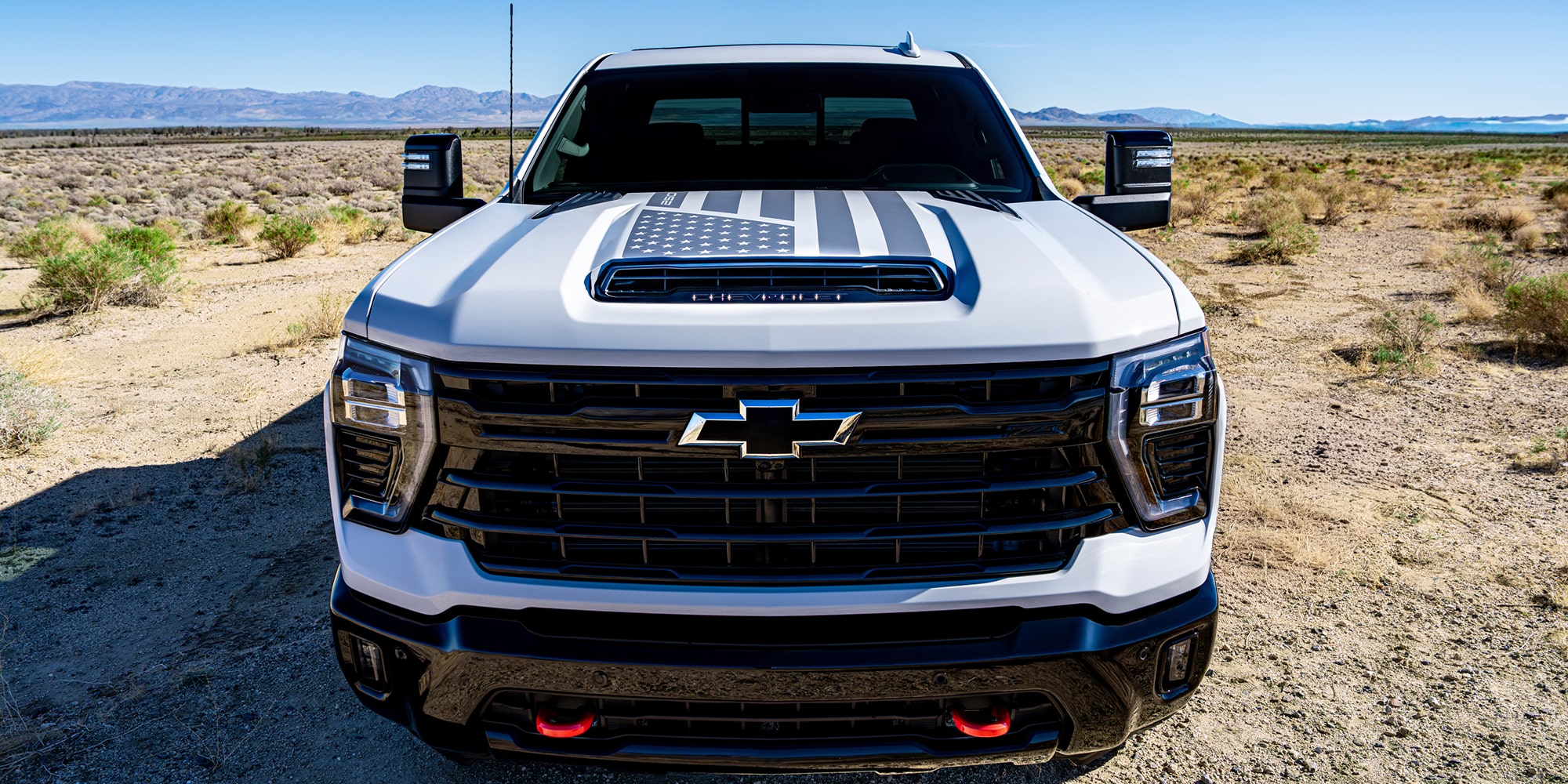 A Frontal View of the Chevrolet Silverado HD Truck, Displaying a Bold Grille and American Flag Hood Decal.