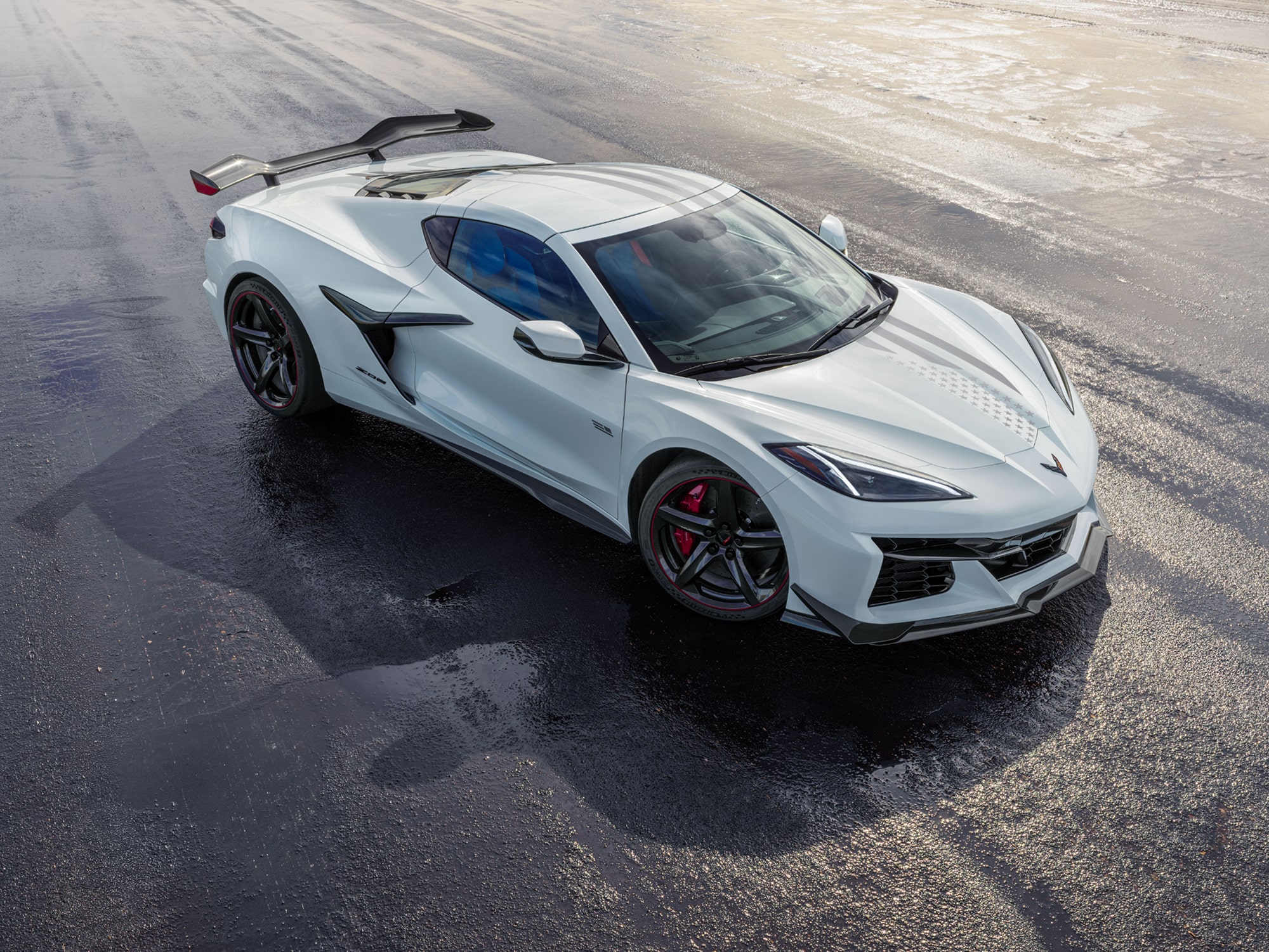A White Chevrolet Corvette Z06 from the Stars and Steel Collection on a Wet Runway.