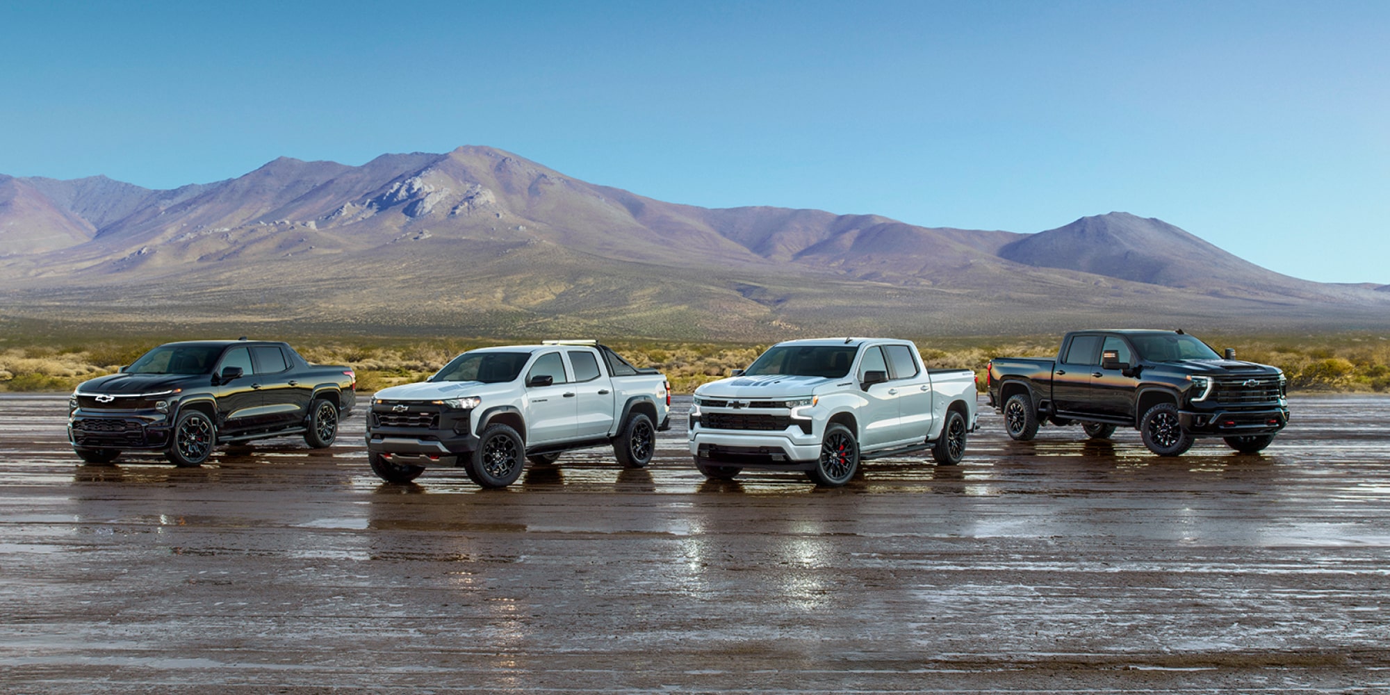 A Collection of Chevrolet Stars and Steel Edition Trucks on a Wet Surface in a Desert.