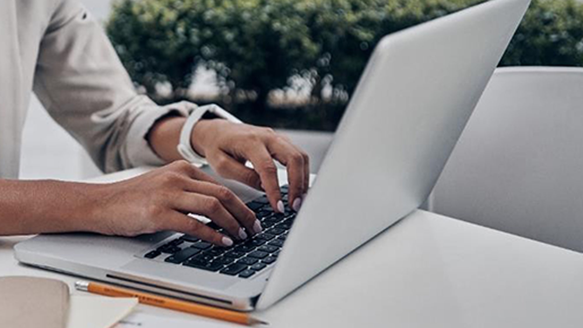A View Showing a Customer Using a Laptop with a notebook and pencil nearby.