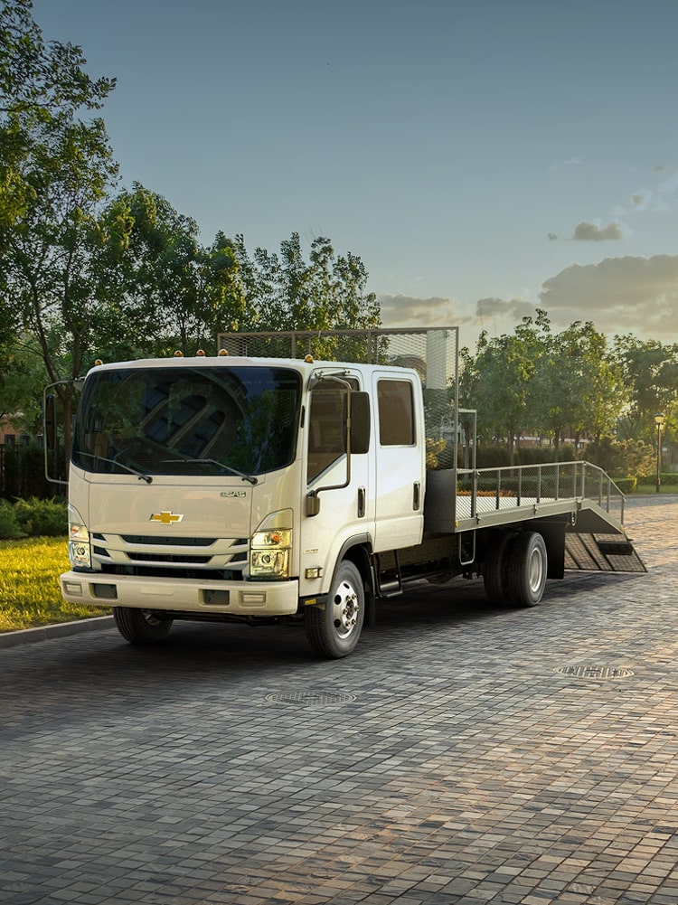 2026 Chevy Low Cab Forward Parked Outside a Home While Hauling Landscaping Equipment