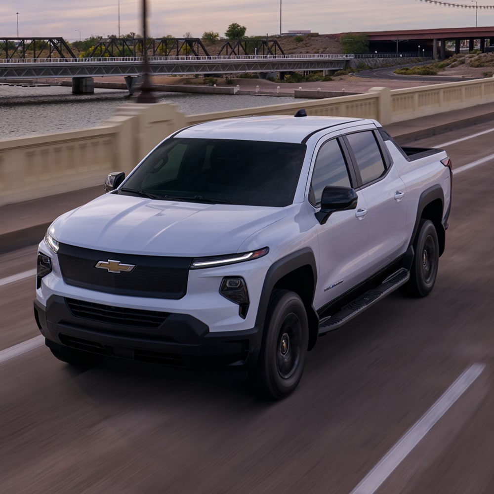 2027 Chevy Commercial Silverado EV Driving Over a Highway Bridge