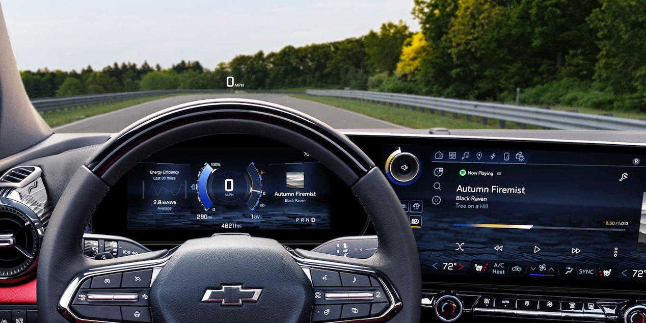 The Interior View of a Chevrolet Blazer EV Featuring a Steering Wheel With the Chevrolet Logo and a Wide Touchscreen Display Showing Navigation and Media Controls.
