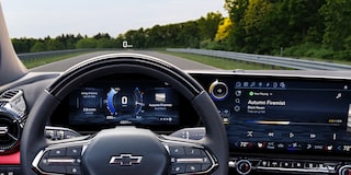 The Interior View of a Chevrolet Blazer EV Featuring a Steering Wheel With the Chevrolet Logo and a Wide Touchscreen Display Showing Navigation and Media Controls.