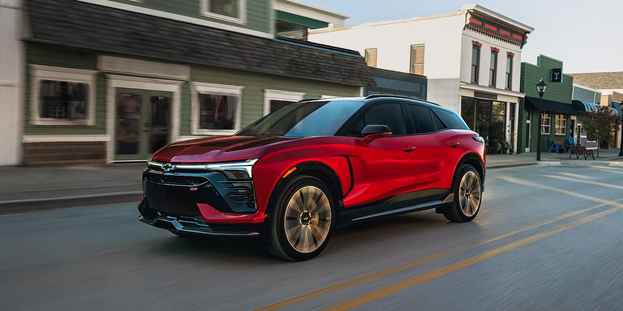 Perfil lateral de una Chevy Blazer EV 2026 andando por un centro urbano