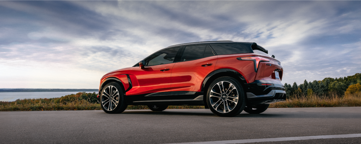 Side Profile View of the 2026 Chevy Blazer EV Parked on a Road Near a Lake