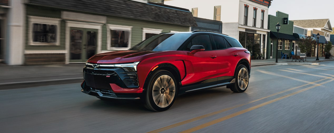Side Profile of the 2026 Chevy Blazer EV Driving Through a Downtown