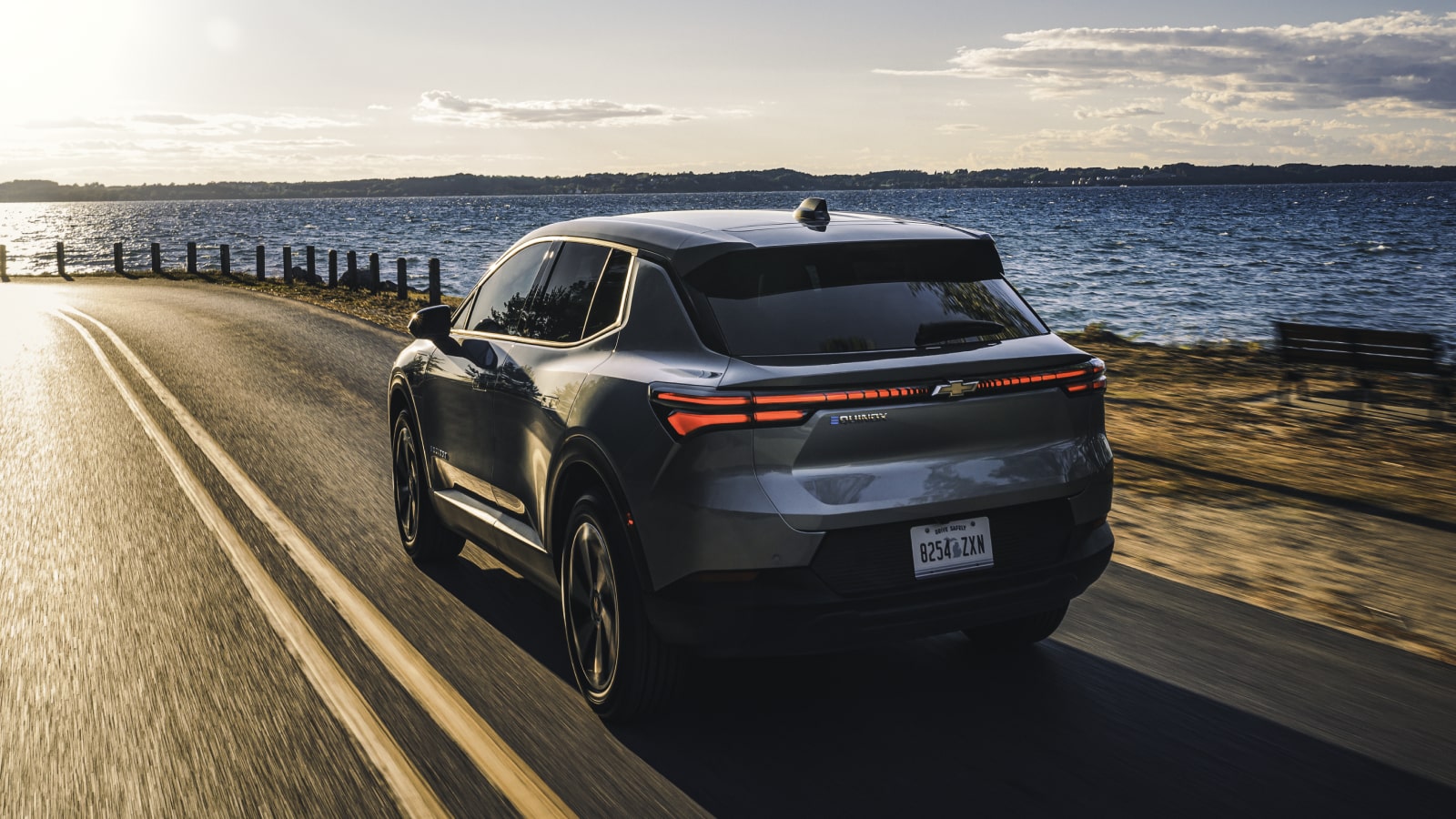 Interior View of a Chevrolet Equinox EV, Showing Hands Adjusting the Large Touchscreen Infotainment System and Dashboard Controls.