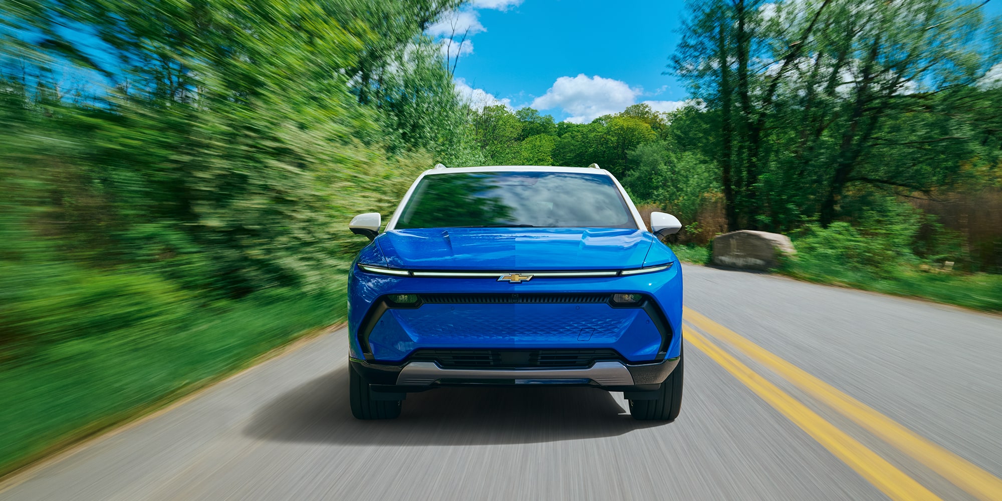 A Blue Chevrolet Equinox EV Driving on a Road