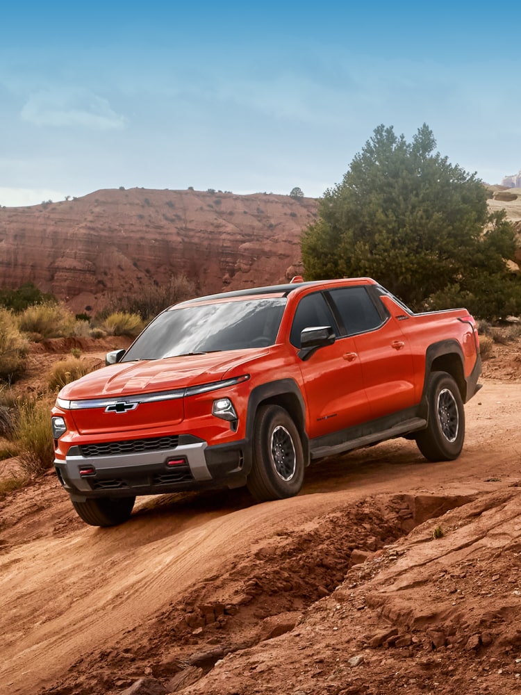 2026 Chevy Silverado EV Driving on Dirt Terrain With Mountains in the Distance