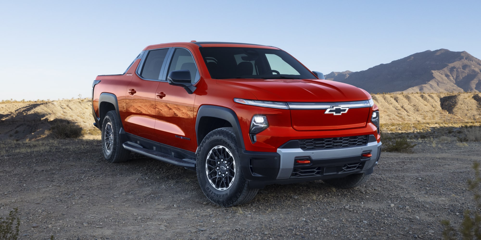 Driver side view of a 2026 Chevy Silverado EV parked in the mountains