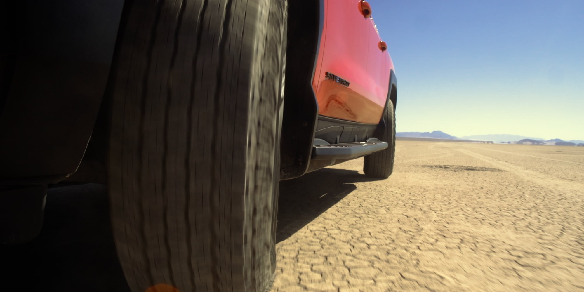 Close-Up View of Wheels on the 2026 Chevy Silverado EV Driving on Western Terrain