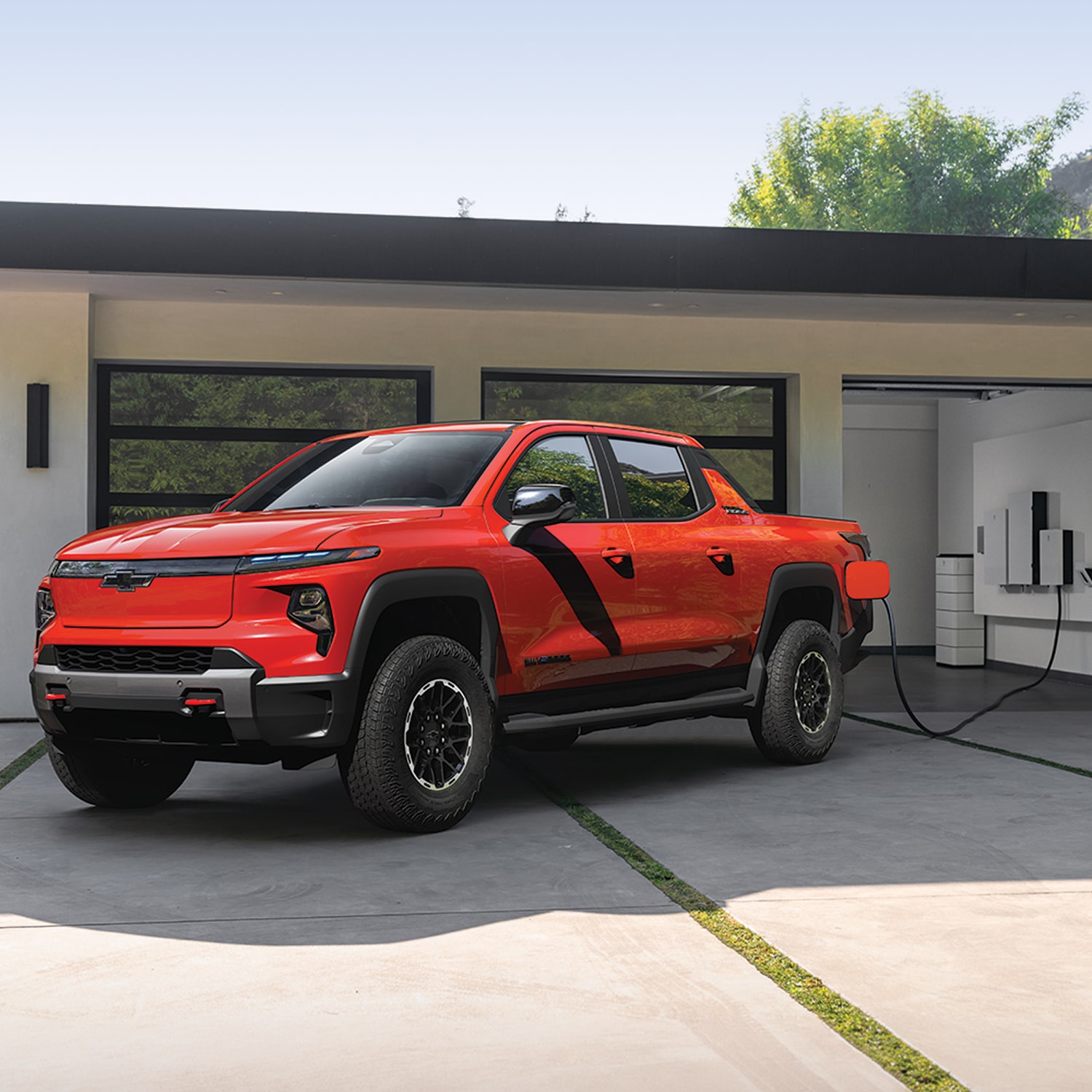 2026 Chevy Silverado EV Parked in a Garage Next to a Home Charging Station