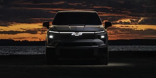 Front View of a 2026 Chevy Silverado EV on the Right Side of the Frame with Its Lights on in Dark Just after Sunset