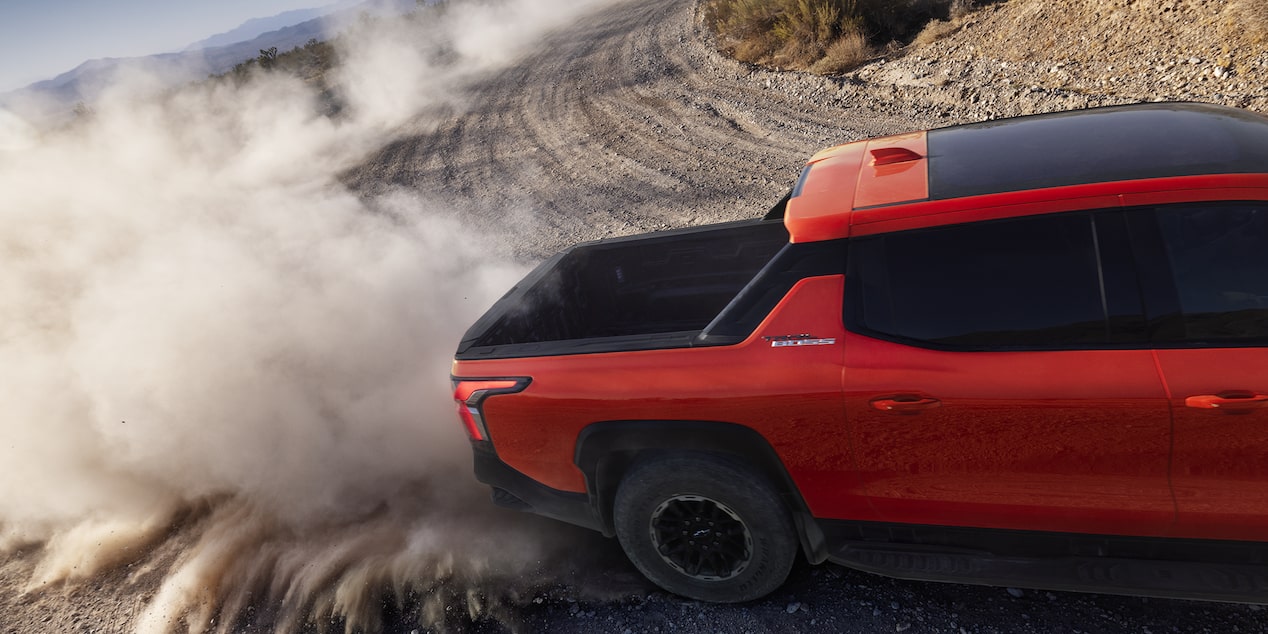 Overhead View of an Orange 2026 Silverado EV Drifting through the Desert with Dust Flying Everywhere