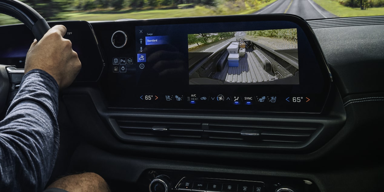 A Man Is Seen Driving a 2026 Chevy Silverado EV with the Display Dashboard Showing Footage of the Cargo in the Back
