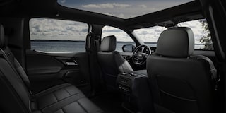 Three Quarters View of the Full Interior of a 2026 Chevy Silverado EV Next to a Body of Water under a Cloudy Sky