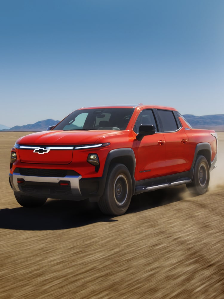 2026 Chevy Silverado EV Driving on Dirt Terrain With Mountains in the Distance