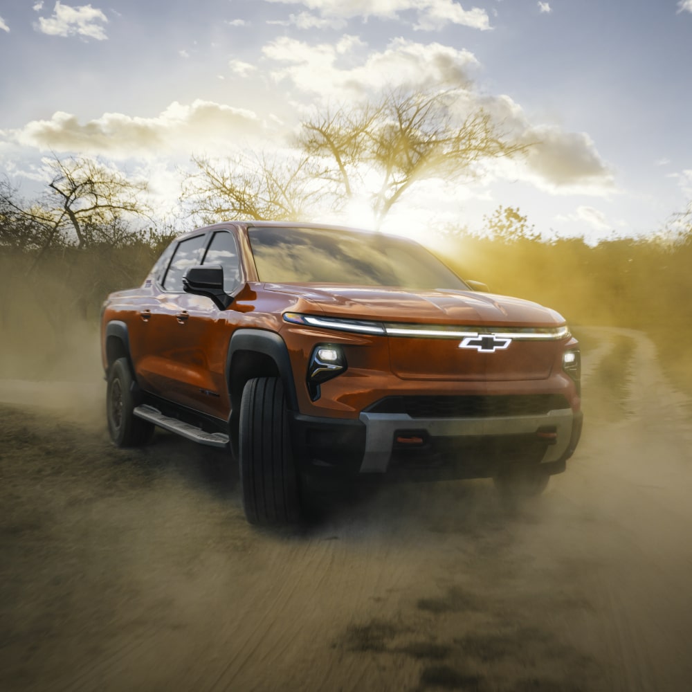 2026 Chevy Silverado EV Driving on a Dirt Road in the Woods