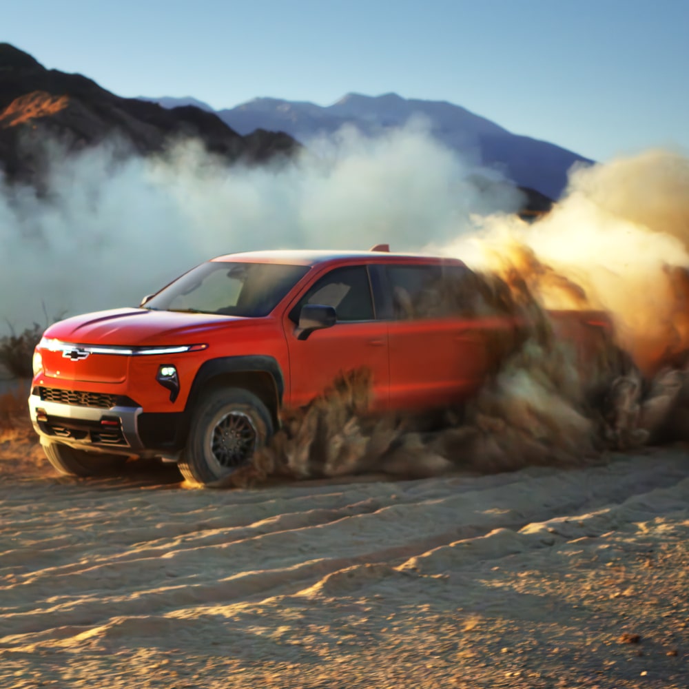 2026 Chevy Silverado EV Parked at Dusk with Mountainous Terrain in the Background