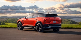 A 2027 Chevy Blazer EV SS Parked at a Scenic Overlook Featuring Black Alloy Wheels, a Contrasting Roof, Sculpted Body Lines, and LED Taillights Visible From a Rear Three-Quarter Angle.