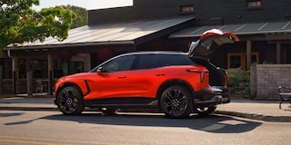 A 2027 Chevy Blazer EV SS Parked in a Residential Driveway With the Rear Liftgate Open, Highlighting Flexible Cargo Access and Spacious Storage Capability.